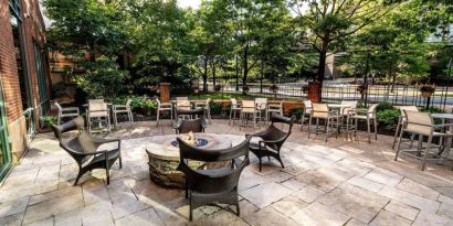 Sonesta Columbus Downtown’s patio features a fire pit that is surrounded by chairs with more tables and chairs nearby.