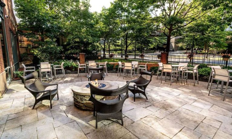 Sonesta Columbus Downtown’s patio features a fire pit that is surrounded by chairs with more tables and chairs nearby.