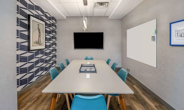 Sonesta Columbus Downtown meeting room, featuring whiteboard and wall-mounted TV, plus a long table and eight chairs.