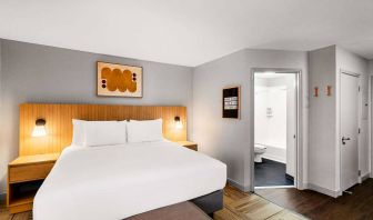 Double bed guest room in Sonesta Simply Suites Austin South, featuring art on the wall and an ensuite bathroom.