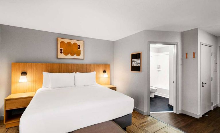 Double bed guest room in Sonesta Simply Suites Austin South, featuring art on the wall and an ensuite bathroom.