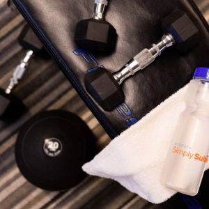 The fitness center in Sonesta Simply Suites Austin South has free weights and benches, plus towels and water.