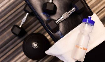 The fitness center in Sonesta Simply Suites Austin South has free weights and benches, plus towels and water.