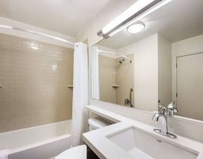 Guest bathroom in Sonesta Simply Suites Austin The Domain Area, featuring bath with a shower, lavatory, mirror and sink.