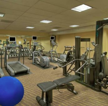 Royal Sonesta Portland Downtown’s fitness center is equipped with free weights, a wall-mounted TV, and assorted exercise machines.