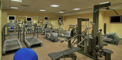 Royal Sonesta Portland Downtown’s fitness center is equipped with free weights, a wall-mounted TV, and assorted exercise machines.