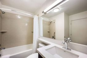 Guest bathroom in Sonesta Simply Suites Houston CityCentre I-10 West, including bath equipped with a shower, mirror, lavatory, and sink.