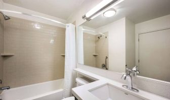 Guest bathroom in Sonesta Simply Suites Houston CityCentre I-10 West, including bath equipped with a shower, mirror, lavatory, and sink.