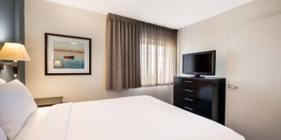 Double bed guest room in Sonesta Simply Suites Dallas Las Colinas, featuring a window and widescreen TV.