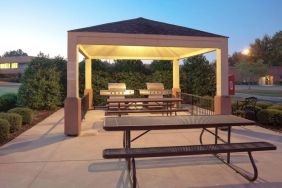 The gazebo at Sonesta Simply Suites Dallas Las Colinas includes barbecue facilities and picnic tables and benches where guests can dine and socialize.