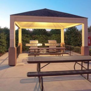 The gazebo at Sonesta Simply Suites Dallas Las Colinas includes barbecue facilities and picnic tables and benches where guests can dine and socialize.