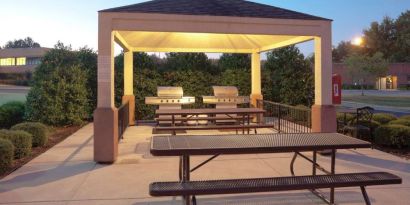 The gazebo at Sonesta Simply Suites Dallas Las Colinas includes barbecue facilities and picnic tables and benches where guests can dine and socialize.