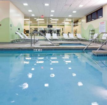 The indoor pool at Sonesta Milwaukee West Wauwatosa has an adjacent hot tub, sun loungers by the side, and is next to the fitness center.