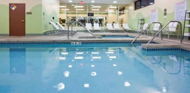 The indoor pool at Sonesta Milwaukee West Wauwatosa has an adjacent hot tub, sun loungers by the side, and is next to the fitness center.