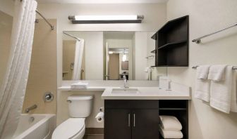 Guest bathroom in Sonesta Simply Suites Hampton, including bathtub, lavatory, mirror, and sink.