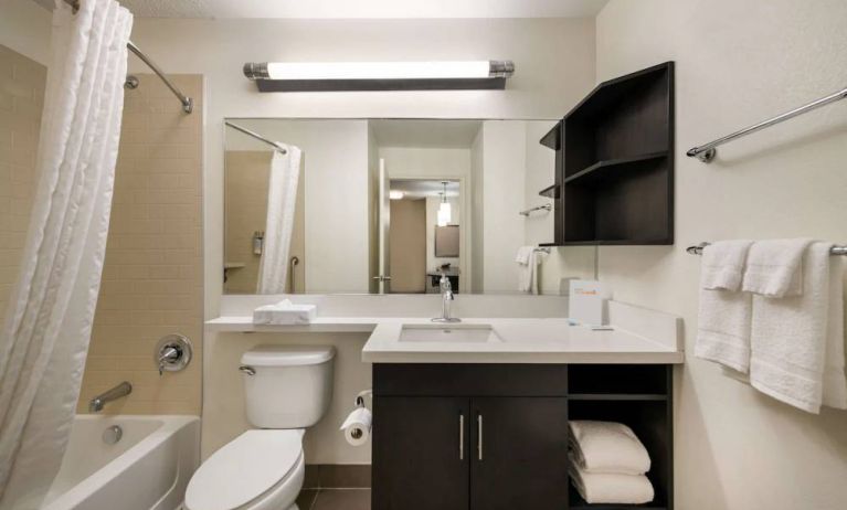 Guest bathroom in Sonesta Simply Suites Hampton, including bathtub, lavatory, mirror, and sink.