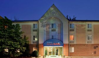 The hotel’s exterior features parking close to the front door and pleasant greenery, including bushes and trees.