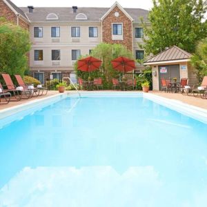 The outdoor pool of Sonesta ES Suites Dallas Las Colinas has tables and chairs, as well as sun loungers, by the side.