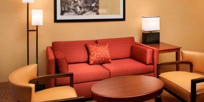 Sonesta Select Detroit Auburn Hills guest room living area, including two chairs, coffee tables, and a sofa.