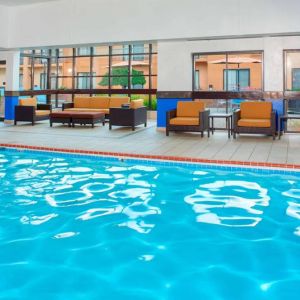 Sonesta Select Detroit Auburn Hills’ indoor pool has armchair and sofa seating by the side, plus large windows.