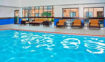 Sonesta Select Detroit Auburn Hills’ indoor pool has armchair and sofa seating by the side, plus large windows.