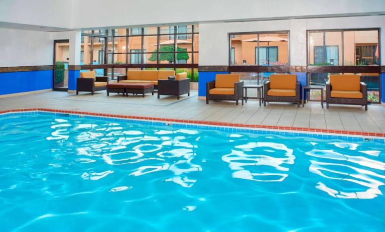 Sonesta Select Detroit Auburn Hills’ indoor pool has armchair and sofa seating by the side, plus large windows.