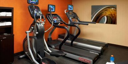 The hotel fitness center has art on the wall and a range of exercise equipment, including treadmills and an elliptical.