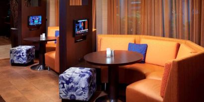 The media pods at Sonesta Select Detroit Auburn Hills are cozy nooks, with each featuring comfy seating, a coffee table, and a TV.