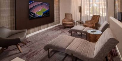 The hotel’s lobby features reclined seats facing a large, wall-mounted TV.