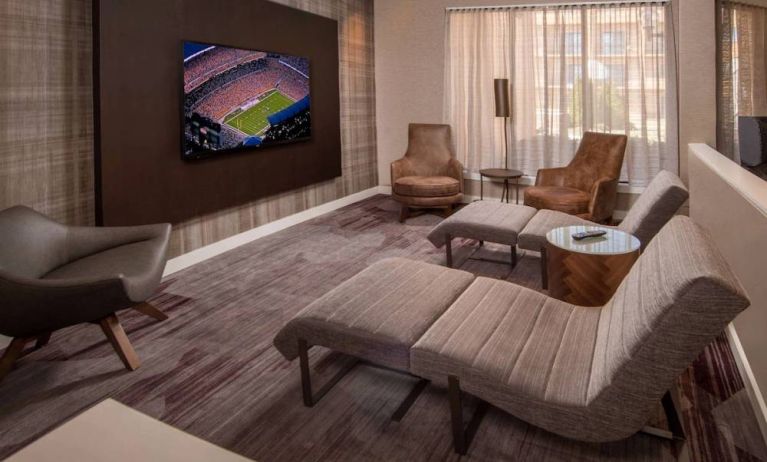 The hotel’s lobby features reclined seats facing a large, wall-mounted TV.