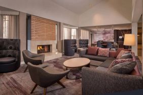 Sonesta Select Columbia’s lobby lounge is furnished with a large sofa and comfy chairs, coffee tables, and a fireplace.