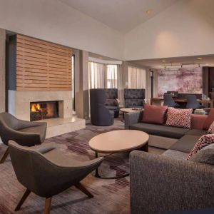 Sonesta Select Columbia’s lobby lounge is furnished with a large sofa and comfy chairs, coffee tables, and a fireplace.