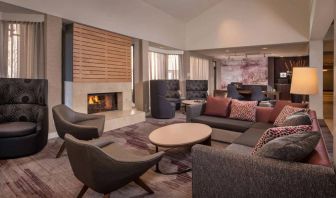 Sonesta Select Columbia’s lobby lounge is furnished with a large sofa and comfy chairs, coffee tables, and a fireplace.