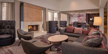 Sonesta Select Columbia’s lobby lounge is furnished with a large sofa and comfy chairs, coffee tables, and a fireplace.