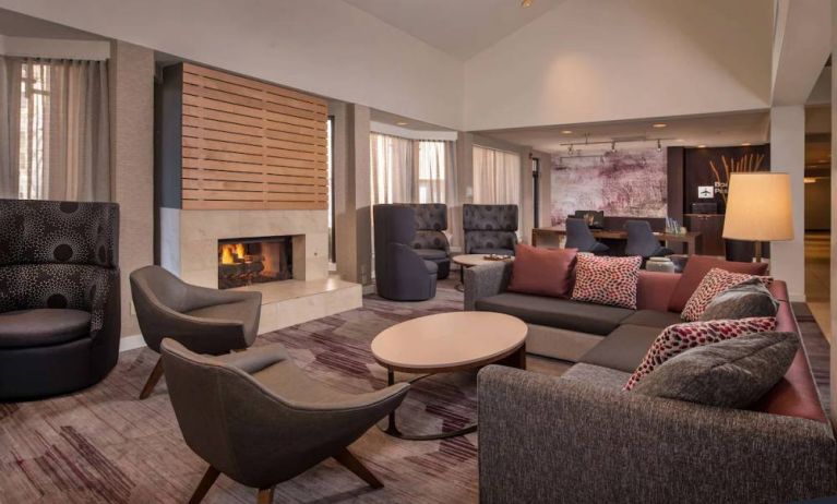 Sonesta Select Columbia’s lobby lounge is furnished with a large sofa and comfy chairs, coffee tables, and a fireplace.