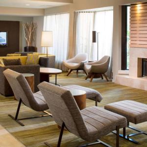 Sonesta Select Boca Raton’s lobby lounge has sofas, chairs, and reclined seats, plus coffee tables, a fireplace, and a wall-mounted television.