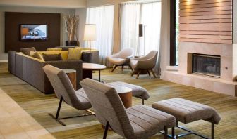 Sonesta Select Boca Raton’s lobby lounge has sofas, chairs, and reclined seats, plus coffee tables, a fireplace, and a wall-mounted television.