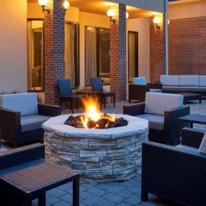 Sonesta Select Indianapolis Carmel’s patio features a fire pit and armchairs, plus coffee tables and sofa seating.