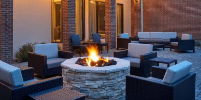 Sonesta Select Indianapolis Carmel’s patio features a fire pit and armchairs, plus coffee tables and sofa seating.