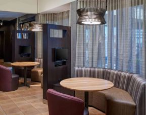 Sonesta Select Indianapolis Carmel’s media pods each feature a TV, coffee table, and comfortable seating next to a window.