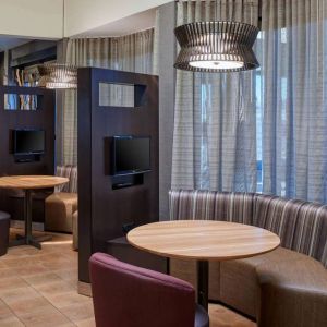 Sonesta Select Indianapolis Carmel’s media pods each feature a TV, coffee table, and comfortable seating next to a window.