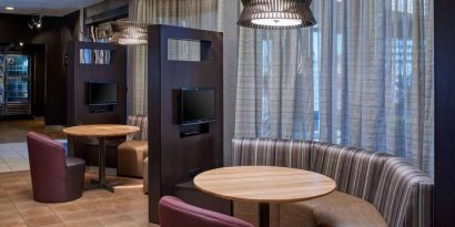 Sonesta Select Indianapolis Carmel’s media pods each feature a TV, coffee table, and comfortable seating next to a window.