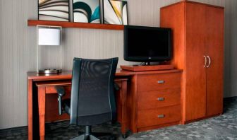 Guest room workspace in Sonesta Select Whippany Hanover, featuring a TV, lamp, desk, and chair.