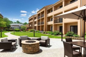 The hotel fire pit has comfy armchairs around it, with a shaded table and chairs nearby.