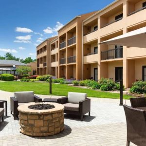 The hotel fire pit has comfy armchairs around it, with a shaded table and chairs nearby.