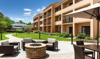 The hotel fire pit has comfy armchairs around it, with a shaded table and chairs nearby.