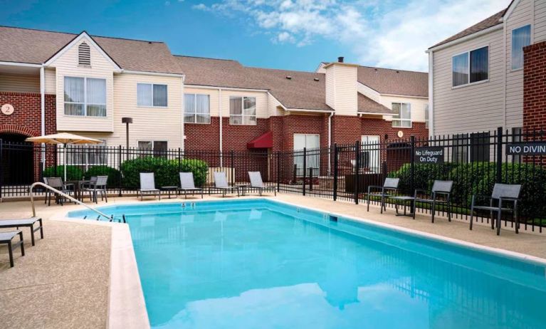 Sonesta ES Suites Annapolis’ outdoor pool has a shaded table and chairs, loungers, and chairs by the side.