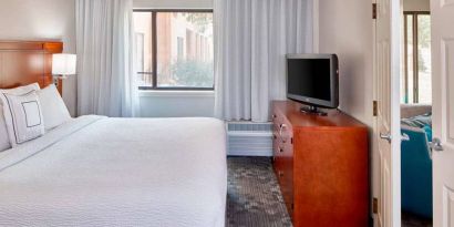 Double bed guest room in Sonesta Select Raleigh Durham Airport Morrisville, featuring a window and a television.