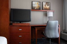 Sonesta Select Phoenix Camelback guest room workspace, including desk, chair, and lamp, plus a TV.