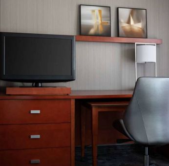 Sonesta Select Phoenix Camelback guest room workspace, including desk, chair, and lamp, plus a TV.